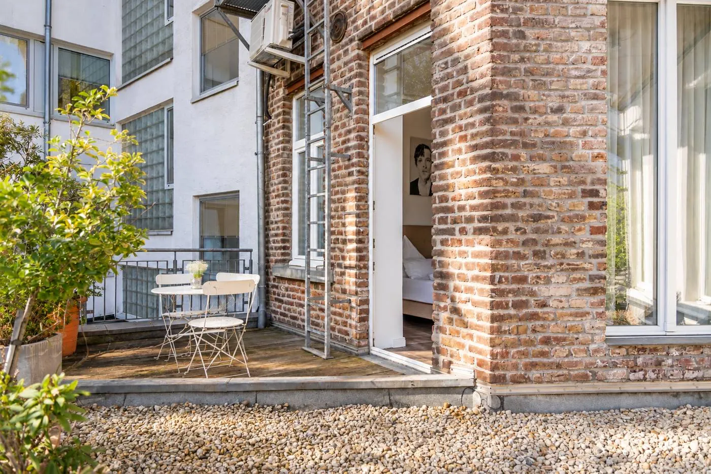 Terrasse eines Deluxe Zimmers im Maison Marsil mit Bistro-Set und offener Tür ins Zimmer